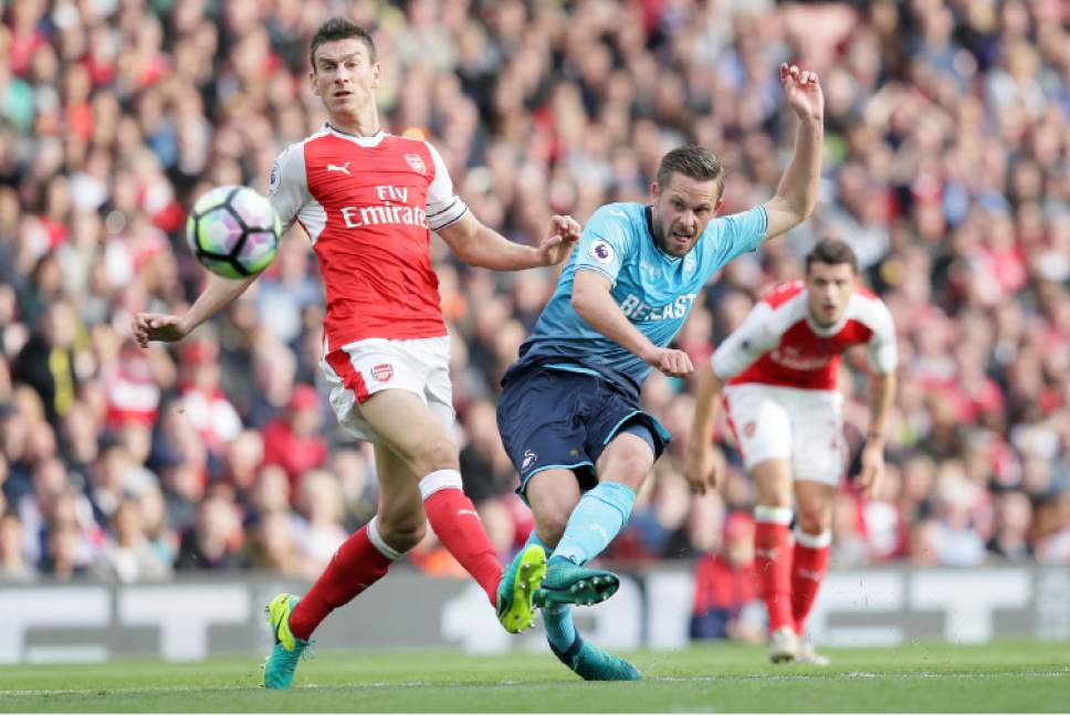Swansea's Gylfi Sigurosson, right, scores a goal past Arsenal's Laurent Koscielny during the English Premier League soccer match between Arsenal and Swansea City at The Emirates Stadium in London, Saturday Oct. 15, 2016. (AP Photo/Tim Ireland)