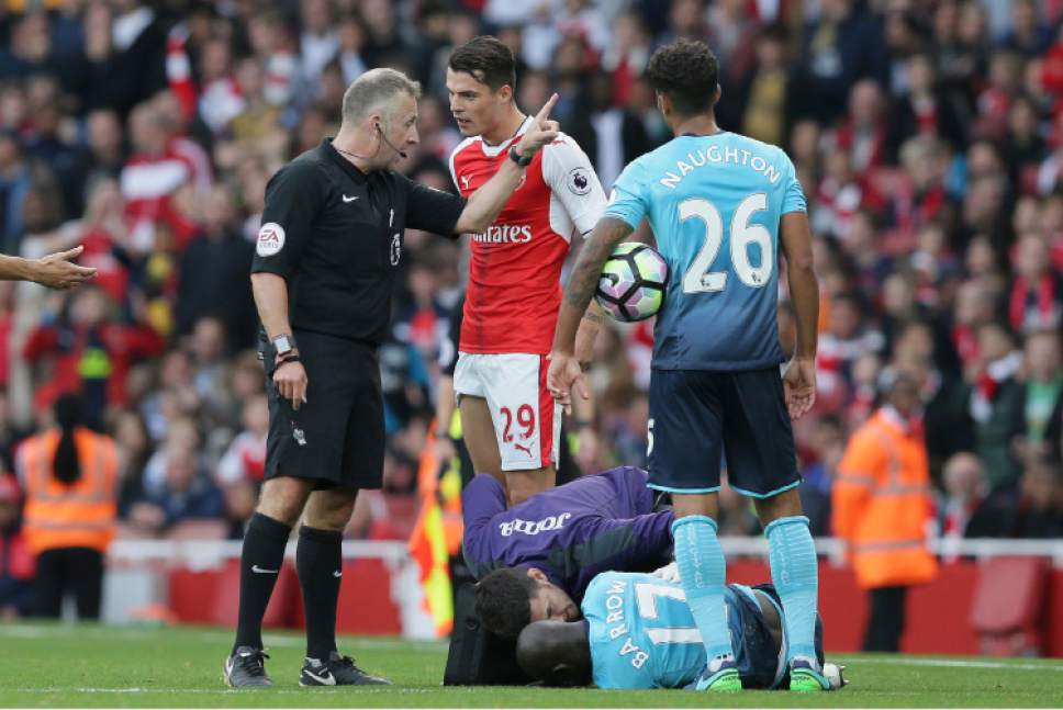 Arsenal's Granit Xhaka, centre, is sent off by referee Jon Moss for a tackle on Swansea's Modou Barrow during the English Premier League soccer match between Arsenal and Swansea City at The Emirates Stadium in London, Saturday Oct. 15, 2016. (AP Photo/Tim Ireland)