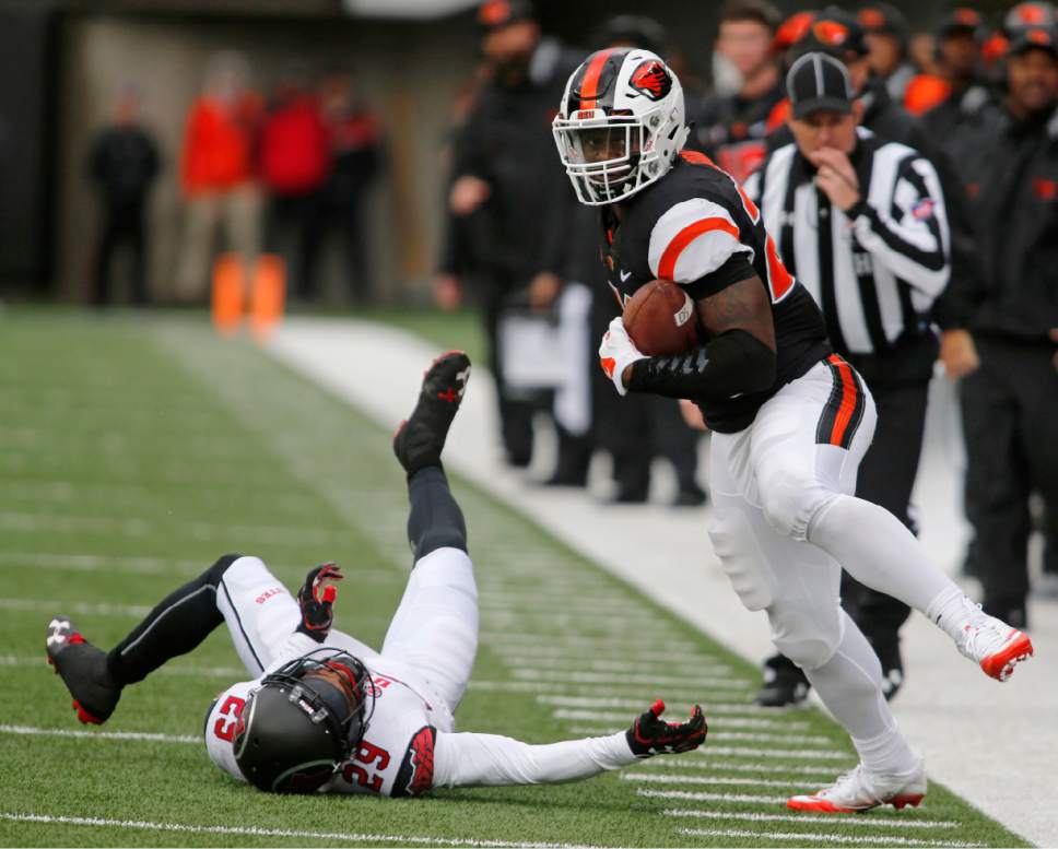 Oregon State running back Tim Cook, right, stays in bounds after avoiding a tackle by Utah's Reggie Porter in the second half of an NCAA college football game in Corvallis, Ore., on Saturday, Oct. 15, 2016. Utah won 19-14. (AP Photo/Timothy J. Gonzalez)