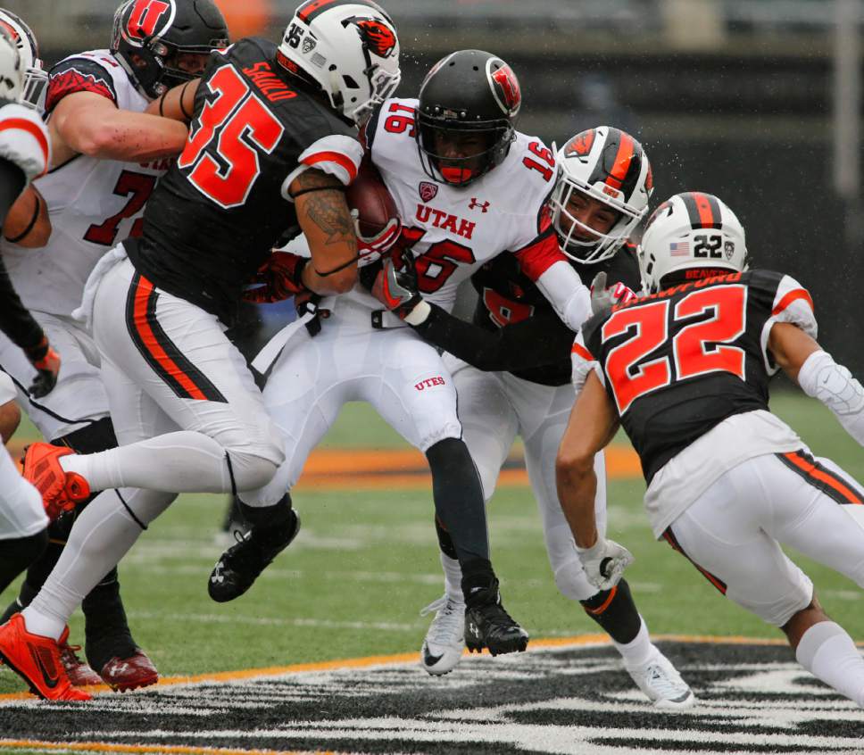 Utah's Cory Butler-Byrd (16) tries to push past Oregon State's Caleb Saulo (35) and Xavier Crawford (12) during the first half of an NCAA college football game in Corvallis, Ore., on Saturday, Oct. 15, 2016. (AP Photo/Timothy J. Gonzalez)