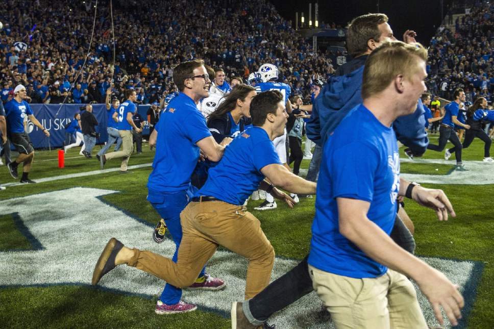 BYU fans run onto the field to celebratestheir 28-21 in double overtime win against Mississippi State in an NCAA college football game in Provo, Utah, Friday, Oct. 14, 2016. (Chris Detrick/The Salt Lake Tribune via AP)