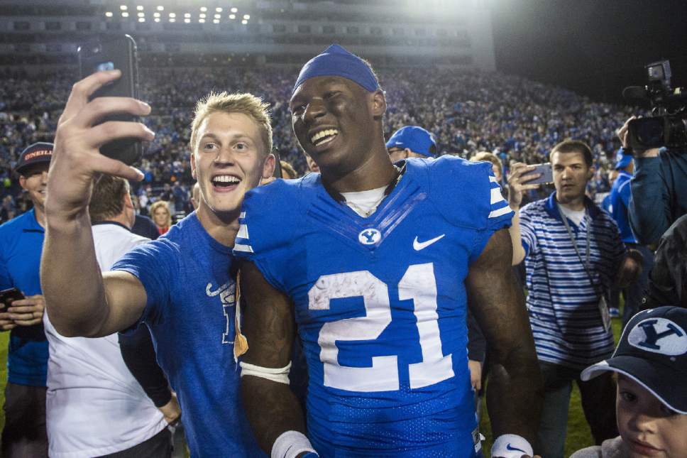 BYU fans take selfies with running back Jamaal Williams (21) after their 28-21 in double overtime win against Mississippi State in an NCAA college football game in Provo, Utah, Friday, Oct. 14, 2016. (Chris Detrick/The Salt Lake Tribune via AP)