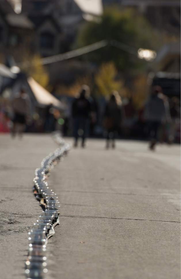 Leah Hogsten  |  The Salt Lake Tribune
Skis and cups lined Main Street in Park City. Wasatch Brew Pub in Park City celebrated its 30th anniversary by attempting to break the world "shot-ski" record, Saturday, October 22, 2016. For the attempt, 1,191 people lined up on Main Street to raise one long ski -- 1,961-feet long with glasses attached-- for a shot of Wastach's premium ale.