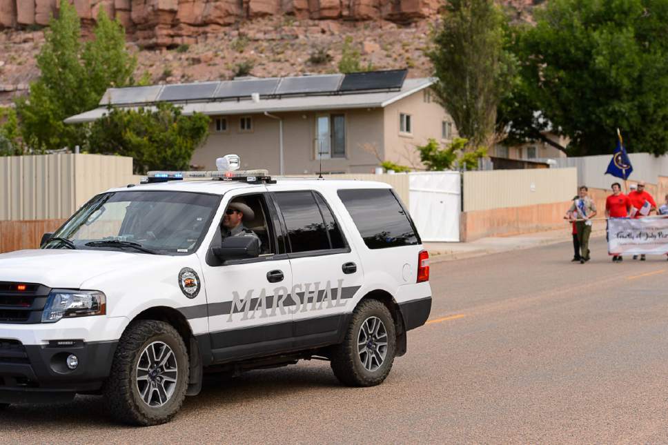 Trent Nelson  |  The Salt Lake Tribune
With a wall-off compound in the background, a Colorado City Marshal vehicle leads the way as the Colorado City and Hildale Fourth of July Parade makes its way down Central Street in Hildale, UT, and Colorado City, AZ, Saturday July 2, 2016.