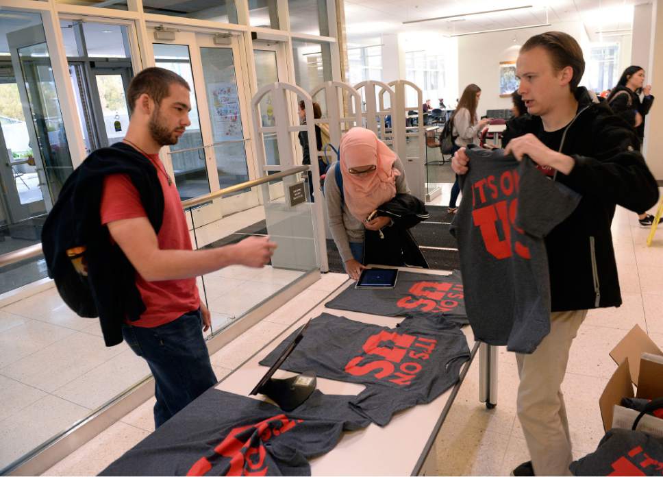 Al Hartmann  |  The Salt Lake Tribune
Derek Eyre with ASUU, right, gives a T-shirt in thanks to University of Utah student Grayson Harness after signing the "It's on Us" pledge in support for sexual assault victims at the entrance to the Marriott Library Monday October 24.  
The university conducted a campus climate survey, and most students say they have no idea where to report assaults.