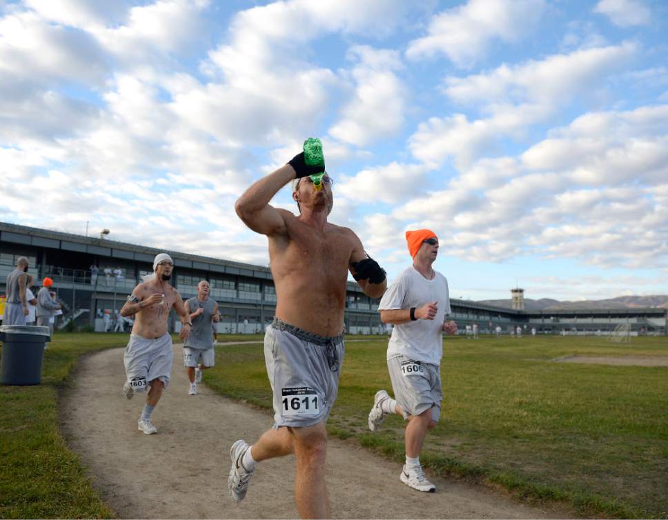 Al Hartmann  |  The Salt Lake Tribune
Inmates at the Utah State Prison-Draper run the enclosed excercise yard-track at the start of the Draper Invitational Marathon, Half-Marathon and 10K races Tuesday morning October 25. A group of four frontrunners grab some water and stick together for the first part of the race. 110 times around the track for the full marathon.