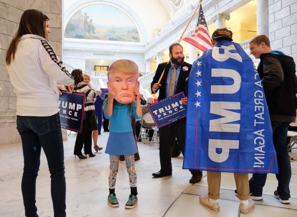 Francisco Kjolseth | The Salt Lake Tribune
Anne Morris, left, of Bountiful is joined by her daughter Gabriella, 9, behind the mask as they attend a Donald Trump rally in the rotunda of the Utah Capitol, on Tuesday, Nov. 1, 2016.