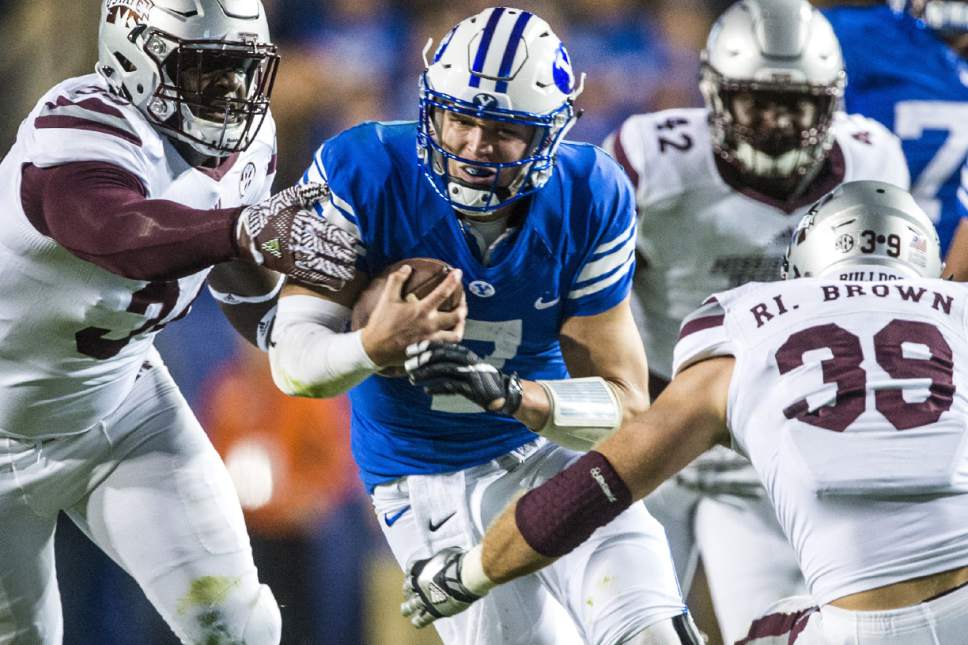 BYU quarterback Taysom Hill (7) runs past Mississippi State defensive lineman Cory Thomas (34) and linebacker Richie Brown (39) during an NCAA college football game in Provo, Utah, Friday, Oct. 14, 2016. (Chris Detrick/The Salt Lake Tribune via AP)