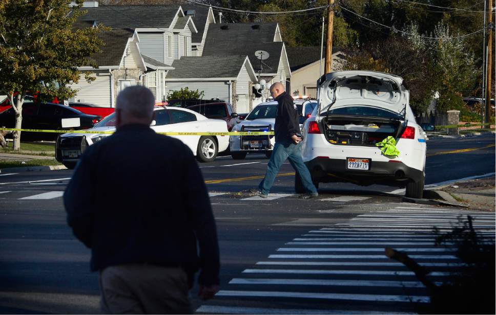 Scott Sommerdorf   |  The Salt Lake Tribune  
Officers and investigators at the scene where West Valley City officer Cody Brotherson was struck and killed by a vehicle near 4100s, and 2200w in West Valley City, Sunday, November 6, 2016. Officer Brotherson's car is at right with it's trunk open. Preliminary information suggests that he may have been trying to lay tire spikes in the roadway when he was hit.