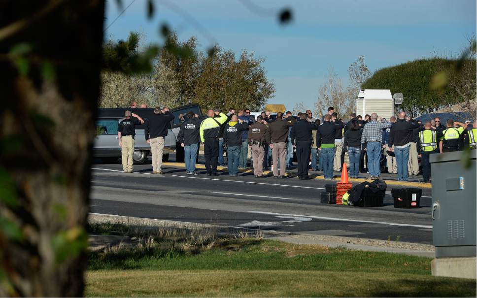 Scott Sommerdorf   |  The Salt Lake Tribune  
Officers and colleagues stand and salute during an impromptu ceremony as officer Cody Brotherson's body was about to be taken from the scene where the West Valley City officer was struck and killed by a vehicle near 4100s, and 220w in West Valley City, Sunday, November 6, 2016.
