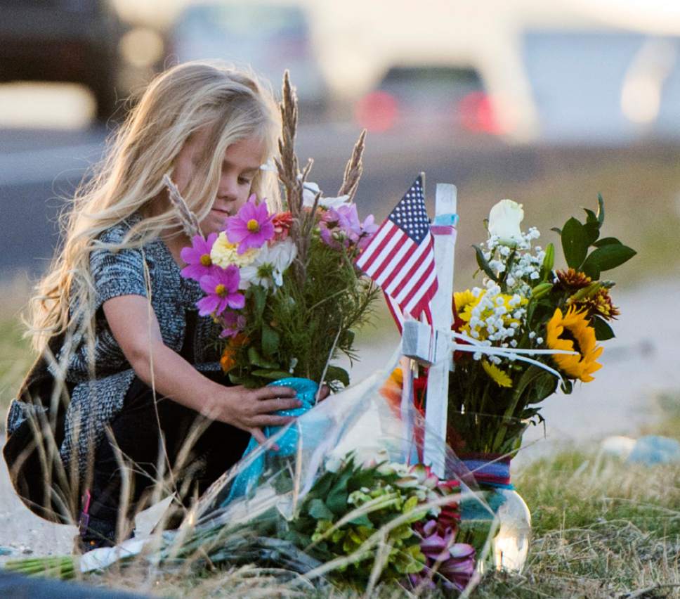 Rick Egan  |  The Salt Lake Tribune

Addy Naisbitt, 5 adds some flowers to a memorial for West Valley Police officer Cody Brotherson, who was killed in the line of duty early this morning in West Valley City, Sunday, November 6, 2016.