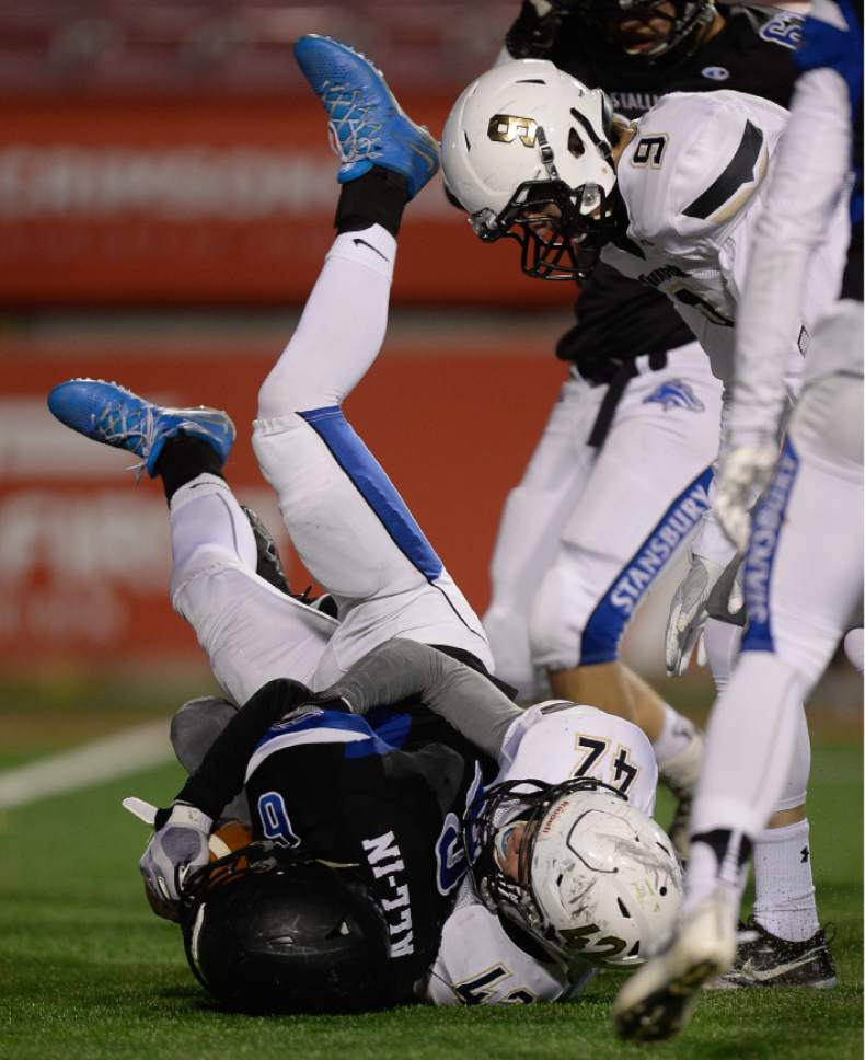 Francisco Kjolseth | The Salt Lake Tribune
Stansbury quarterback Mitchell McIntyre gets upended by        Tyler Warner of Desert Hills during the 3AA semifinal football game at Rice-Eccles Stadium on the University of Utah campus in Salt Lake City Thursday, Nov. 10, 2016.