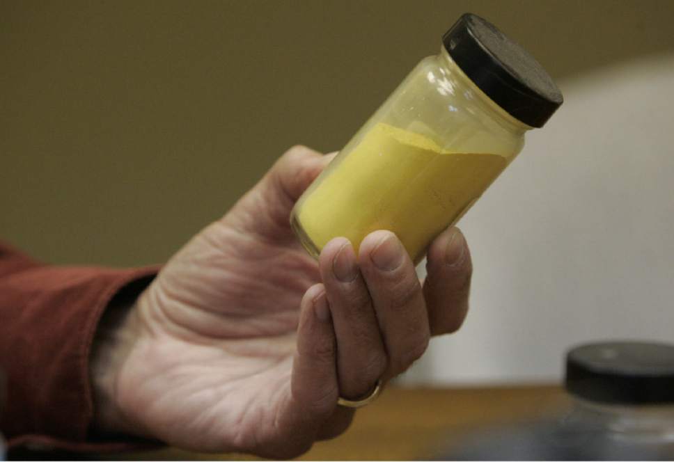 Blanding, UT. Harold Roberts holds a sample of "Yellow Cake" at the White Mesa Mill that processes uranium outside Blanding, Utah. Yellow Cake is product of the mill after processing ore containing uranium. 5/23/07  Jim Urquhart/Salt Lake Tribune