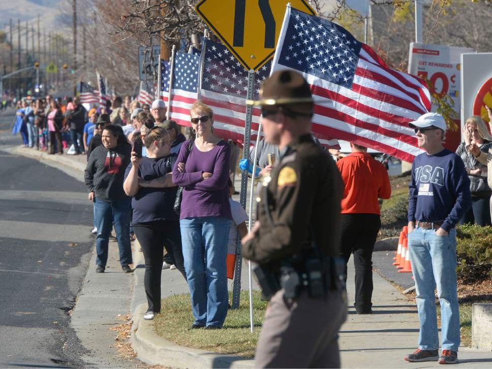 Al Hartmann  |  The Salt Lake Tribune
Hundreds of people fill the sides of the street along 4100 South near 4000 West in West Valley City Monday Nov. 14 to pay final respects to Police Officer Cody Brotherson. He was killed in the line of duty Nov. 6 when he was hit by a car he was trying to stop with tire spikes.  The funeral procession with hundreds of law enforcement cars stretched from the Maverik Center all the way to Valley View Memorial Park several miles away.