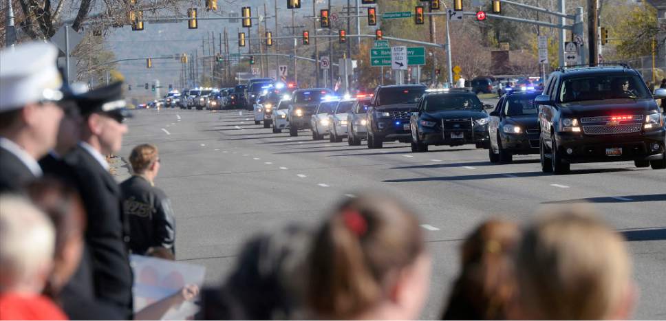 Al Hartmann  |  The Salt Lake Tribune
Hundreds of people fill the sides of the street along 4100 South near 4000 West in West Valley City Monday Nov. 14 to pay final respects to Police Officer Cody Brotherson. He was killed in the line of duty Nov. 6 when he was hit by a car he was trying to stop with tire spikes.  The funeral procession with hundreds of law enforcement cars stretched from the Maverik Center all the way to Valley View Memorial Park several miles away.