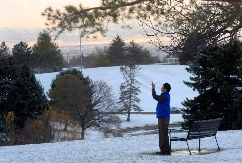 Al Hartmann  |  The Salt Lake Tribune
Man takes pictures of the first snow of the season in Sugarhouse Park Thursday morning Nov. 17 as the storm begins to break up in the west part of the valley.