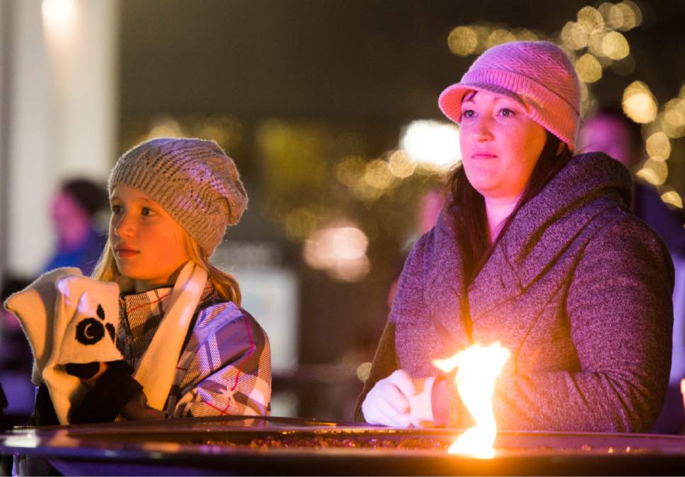 Rick Egan  |  The Salt Lake Tribune

Bailey Kotter, 10 keeps warm by the fire pit with her mother Andrea, at the16th annual "Light Up The Night" Christmas tree lighting party, Saturday, November 19, 2016.