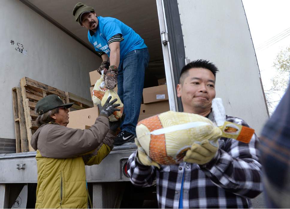 Al Hartmann  |  The Salt Lake Tribune
Volunteers form a human conveyor belt unloading frozen turkeys from a truck and into the Urban Indian Center in Salt Lake City Wednesday, Nov. 23, 2016.   Crossroads Urban Center, Utah Food Bank and volunteers from civic and business organizations gave away 3,400 turkeys and extras for a Thanksgiving Day meal.  The turkeys and food were donated by Harmon Grocery stores and their customers.