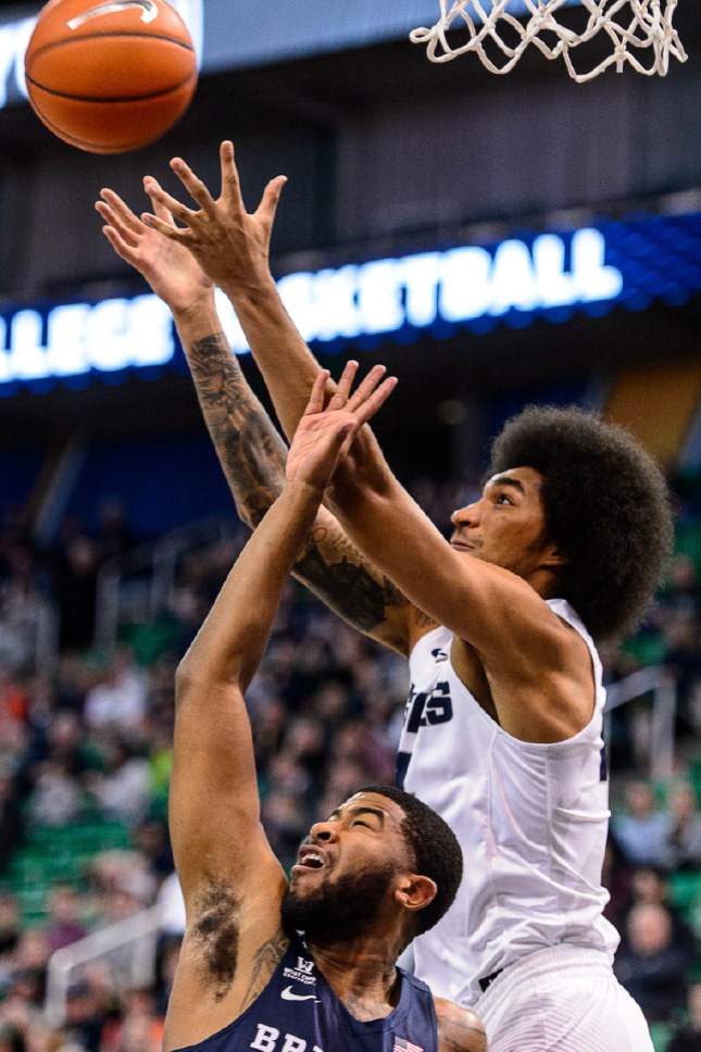 Trent Nelson  |  The Salt Lake Tribune
Utah State Aggies forward Jalen Moore (14) pulls down a rebound over Brigham Young Cougars guard L.J. Rose (5) as BYU faces Utah State, NCAA basketball in Salt Lake City, Wednesday November 30, 2016.