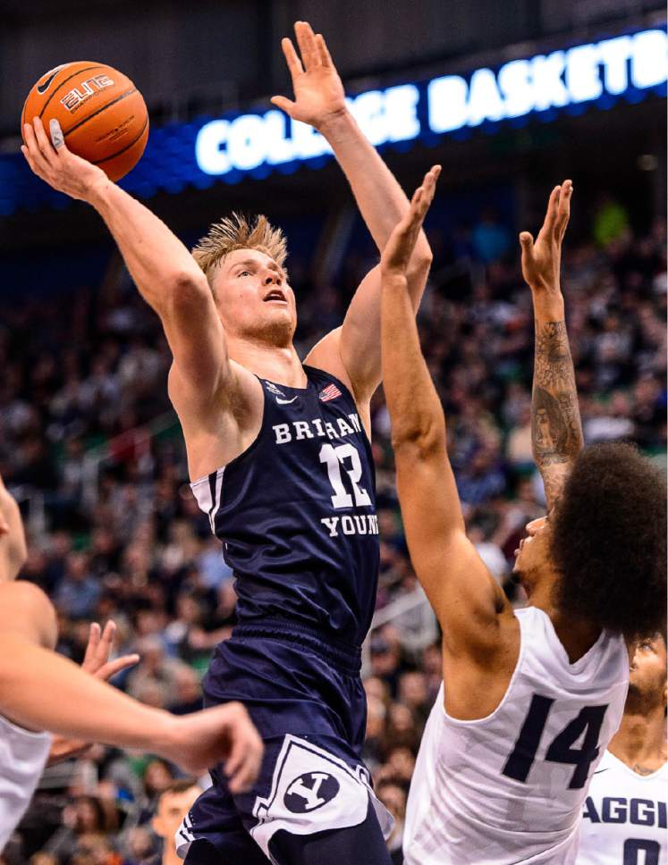 Trent Nelson  |  The Salt Lake Tribune
Brigham Young Cougars forward Eric Mika (12) shoots over Utah State Aggies forward Jalen Moore (14) as BYU faces Utah State, NCAA basketball in Salt Lake City, Wednesday November 30, 2016.