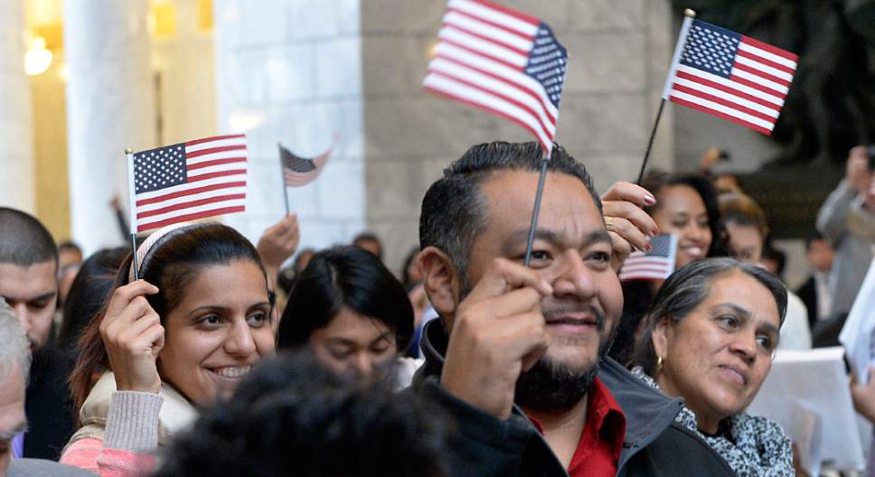Al Hartmann  |  The Salt Lake Tribune
101 people from 43 countries wave American flags after taking the Oath of Allegiance to make them new American citizens at a Naturalization Ceremony on Wednesday at the Utah State Capitol.