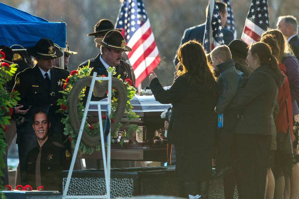 Chris Detrick  |  The Salt Lake Tribune
Family, friends and law enforcement officers pay their respects during the burial of Utah Highway Patrol Trooper Eric Ellsworth at Brigham City Cemetery Wednesday November 30, 2016. Ellsworth was hit by a car on the night of November 18, 2016 while trying to alert the driver of a semitrailer truck to go around a downed power line in Box Elder County. He died four days later.