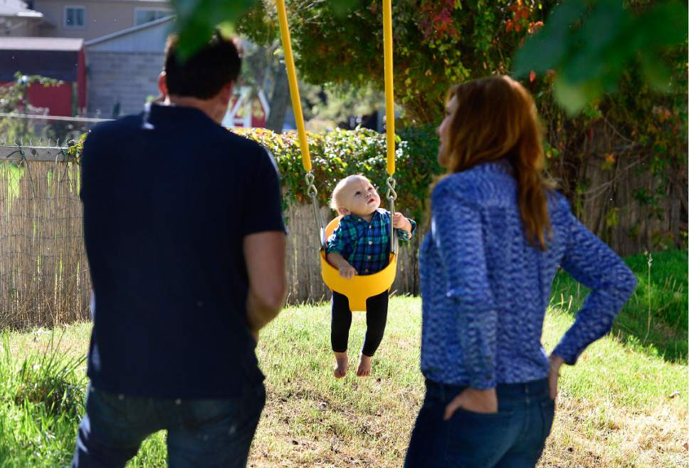 Scott Sommerdorf   |  The Salt Lake Tribune  
Adoptive parents Jayson Orvis, left, and Pamela Orvis, right, tend to their  young son on a swing at the home of the baby's birth mother, Kim Hawkins, Wednesday, September 28, 2016.