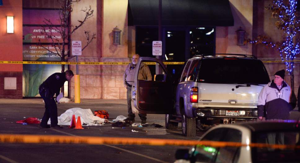 Francisco Kjolseth | The Salt Lake Tribune
The body of a male suspect lies in the parking lot of the Cinemark in American Fork after he was shot at by police following a brief pursuit on Sunday night, Dec. 4, 2014. Police say he may have died from a self-inflicted gunshot. The suspect is believed to have just shot and killed a woman in her car by a Walmart nearby.