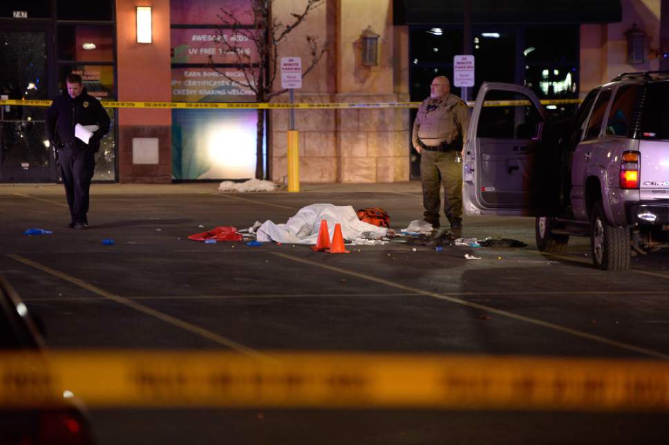 Francisco Kjolseth | The Salt Lake Tribune
The body of a male suspect lies in the parking lot of the Cinemark in American Fork where he was shot at by police following brief pursuit on Sunday night, Dec. 4, 2014.  Police say he may have died from a self-inflicted gunshot. The suspect is believed to have just shot and killed a woman in her car by a Walmart nearby.