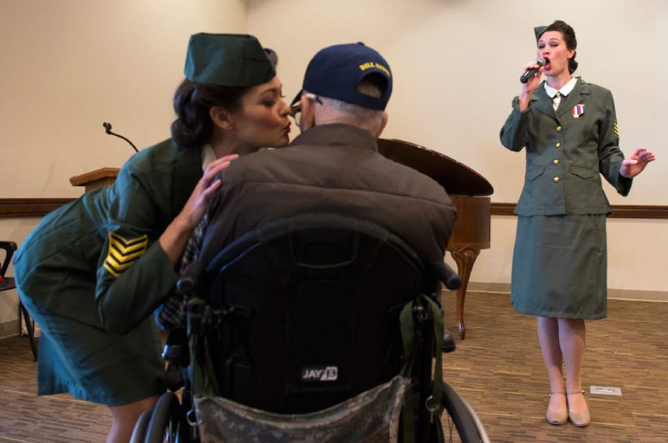 Leah Hogsten  |  The Salt Lake Tribune
The Benson Sisters perform after the renaming ceremony, singing Glen Miller hits from the 1940's. Lisa Benson (left) leans in to kiss Central Utah Veterans Home resident Bill Ritch as Julie Surjopolos sings, at right.   In commemoration of the 75th anniversary of the Japanese attack on Pearl Harbor December 7, 1941, the Central Utah Veterans Home in Payson renamed its facility after Utah's own Capt. Mervyn Sharp Bennion. Bennion, a U.S. Naval Academy graduate from Vernon,  was in command of the USS West Virginia battleship on the morning of Dec. 7, 1941, as Japanese airplanes attacked the U.S. fleet in Hawaii. Bennion was awarded the Medal of Honor for his actions during that day, which ultimately cost him his life.