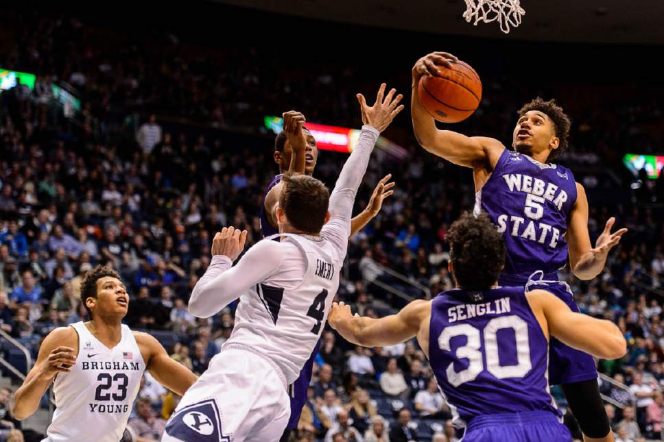 Trent Nelson  |  The Salt Lake Tribune
Weber State Wildcats guard Cody John (5) pulls in a rebound ahead of Brigham Young Cougars guard Nick Emery (4) as BYU hosts Weber State, NCAA basketball at the Marriott Center in Provo, Wednesday December 7, 2016.