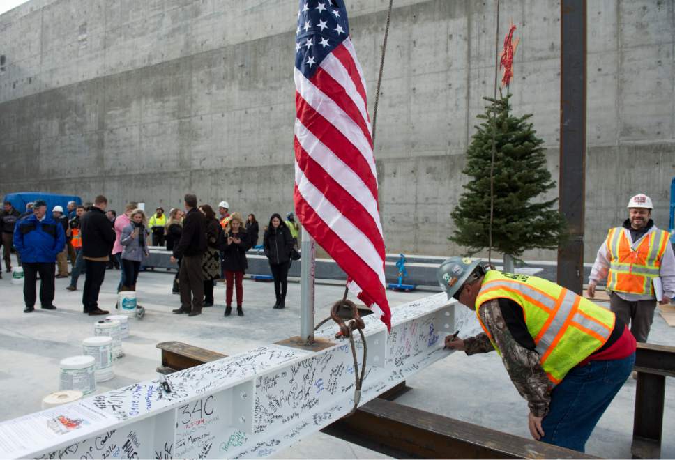 Rick Egan  |  The Salt Lake Tribune

Hale Centre Theatre construction workers sign a 16-foot, 660-pound, signed white beam and an evergreen tree, symbolic of the near completion of the steel structure, in Sandy City, Friday, December 9, 2016.