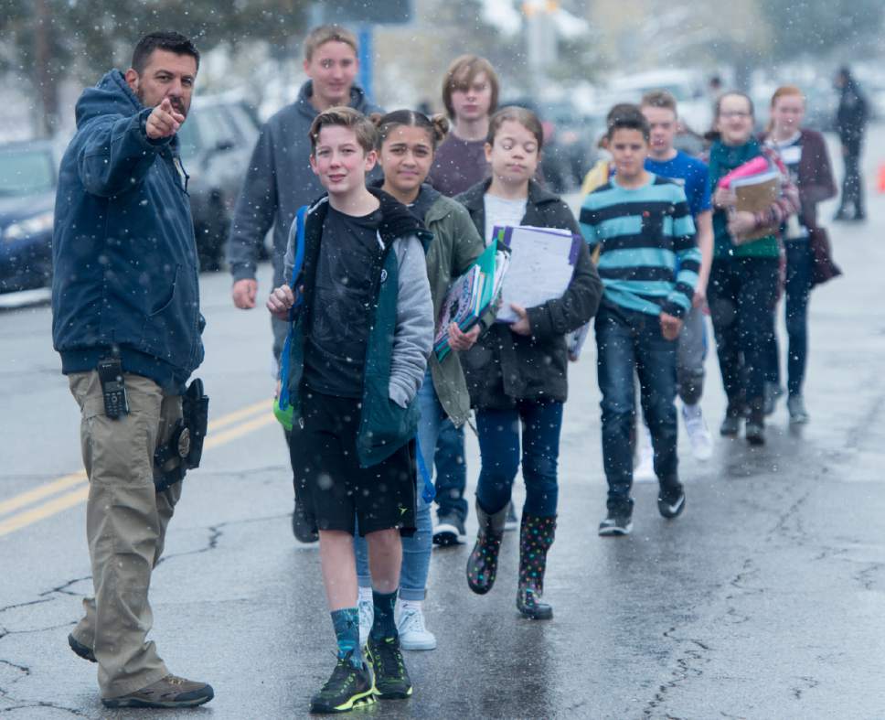 Rick Egan  |  Tribune file photo
A police officer directs Mueller Park Jr. High students to the church where their parents are waiting for them as they are released from school after a shooting at the Bountiful school in 2016.