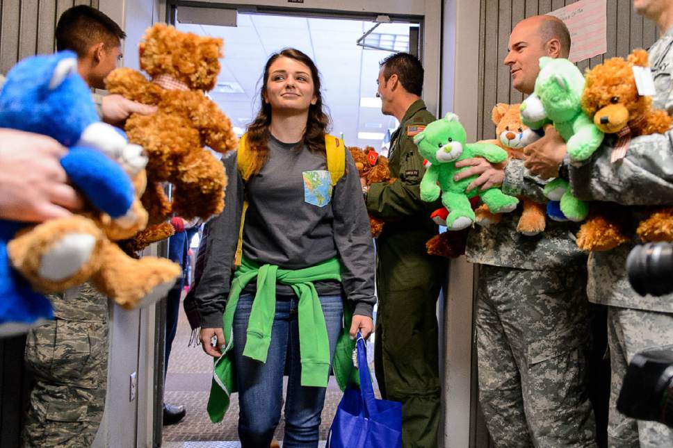 Trent Nelson  |  The Salt Lake Tribune
Maddie Smith is offered a teddy bear by servicemen before takeoff at the Salt Lake City International Airport, Sunday December 11, 2016. About 20 Utah children and adults will join about 1,800 peers in Dallas as part of the 11th Annual Snowball Express. Snowball Express is a nonprofit organization with the goal of "Serving the Children of Our Fallen Military Heroes."