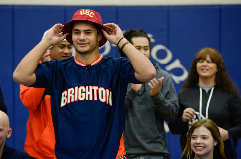 Francisco Kjolseth  |  The Salt Lake Tribune 
Brighton's five-star linebacker Osa Masina, regarded as the top-rated college prospect coming out of Utah, picks up the USC hat as he reveals his school of choice to attend and play during a school assembly held in his honor and other student athletes receiving school scholarships.