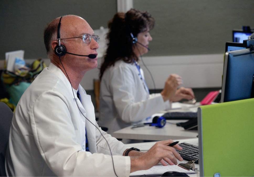 Al Hartmann  |  The Salt Lake Tribune
Physician Assistants Wayne Crawford and Robin Dale talk to patients by teleconference at Intermountain Supply Chain Center in Midvale Monday Dec. 12.  Patients can call in with an ailment and symptoms.  The patients medical records and history are available for the doctors to diagnose and order medications.