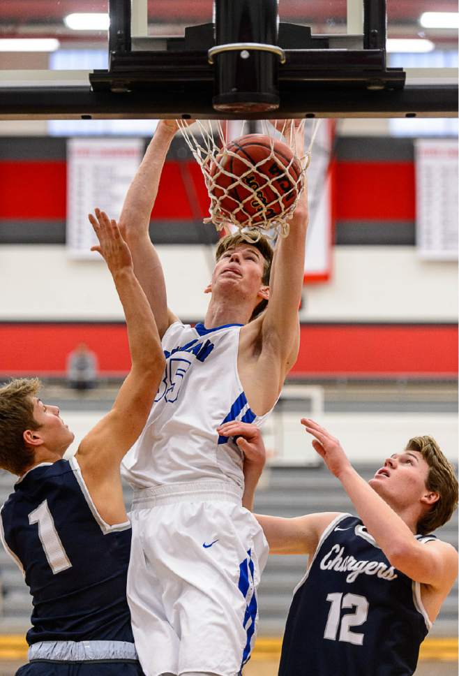 Trent Nelson  |  The Salt Lake Tribune
Bingham's Branden Carlson dunks the ball over Corner Canyon's Zach Wilson and Ammon Savage as Bingham faces Corner Canyon in the first round of the Utah Elite 8 boys' basketball tournament at American Fork High, Thursday December 8, 2016.