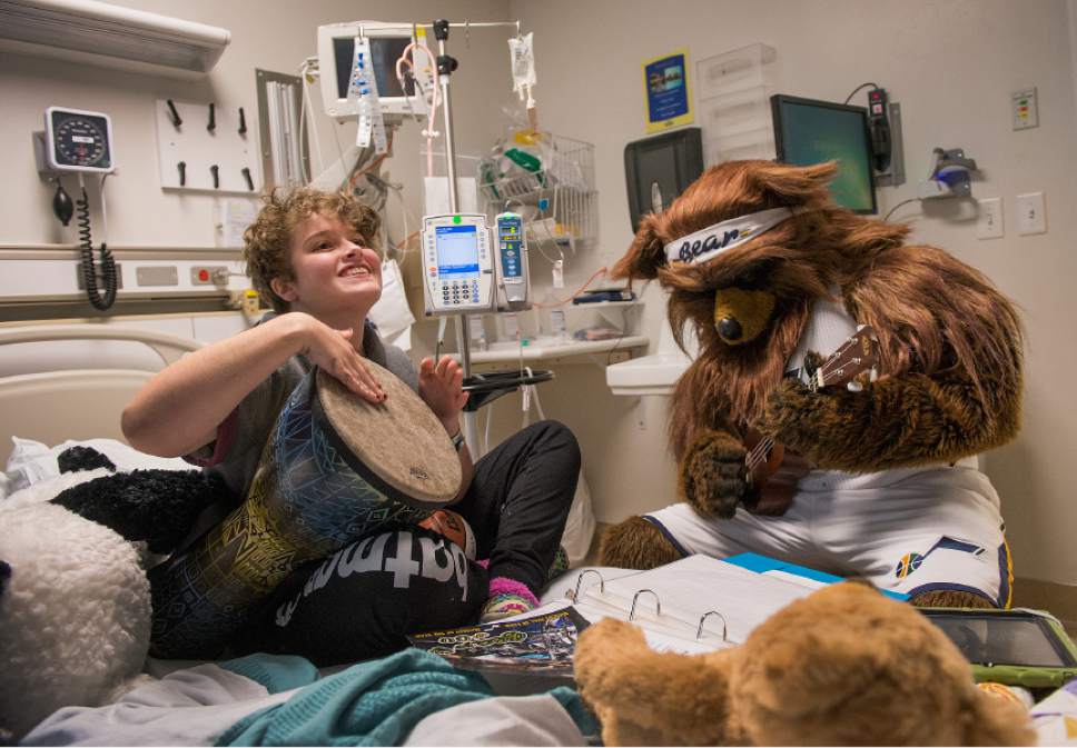 Leah Hogsten  |  The Salt Lake Tribune
Bella Wardle, 16, of Farmington is all smiles as she beats a drum during an impromptu music therapy session with Jazz Bear who played a melody on the ukelele. Players from the Utah Jazz, Salt Lake City Stars players and coaches, Jazz Dancers, Jazz Bear and members of the Wheelin' Jazz  visited Primary Children's Hospital, Thursday, Dec. 15, 2016. The annual Christmas hospital visits are part of the NBA Cares Season of Giving and allow the organization to deliver holiday cheer to patients and their families.