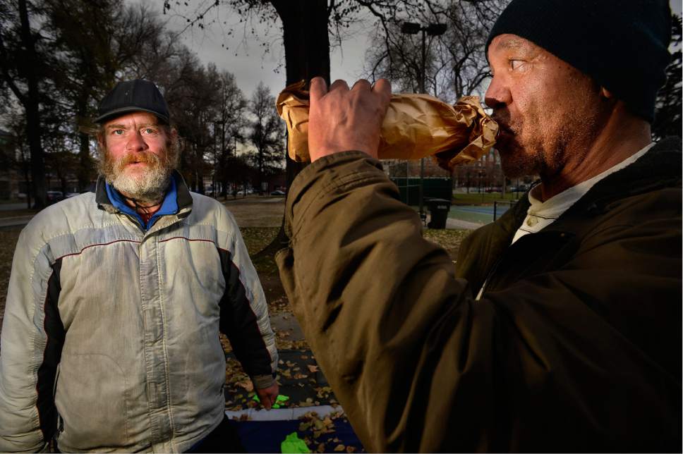 Scott Sommerdorf   |  The Salt Lake Tribune  
Mike Hubertz, left, and his friend Saul Arrington share a cigarette and a bottle as they talk in Pioneer Park, Thursday, December 15, 2016.