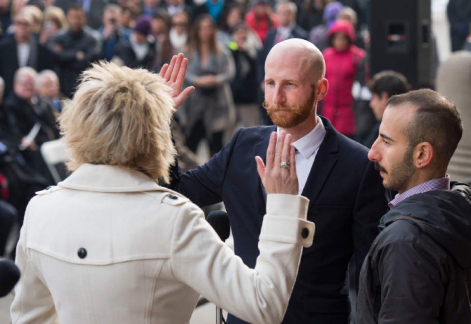 Steve Griffin  |  Tribune file photo

 Salt Lake City Council member Derek Kitchen takes the oath of office administered by city recorder Cindi Mansell, during ceremony at City Hall, Monday, January 4, 2016. Kitchen is joined by his husband Moudi Sbeity for the event.