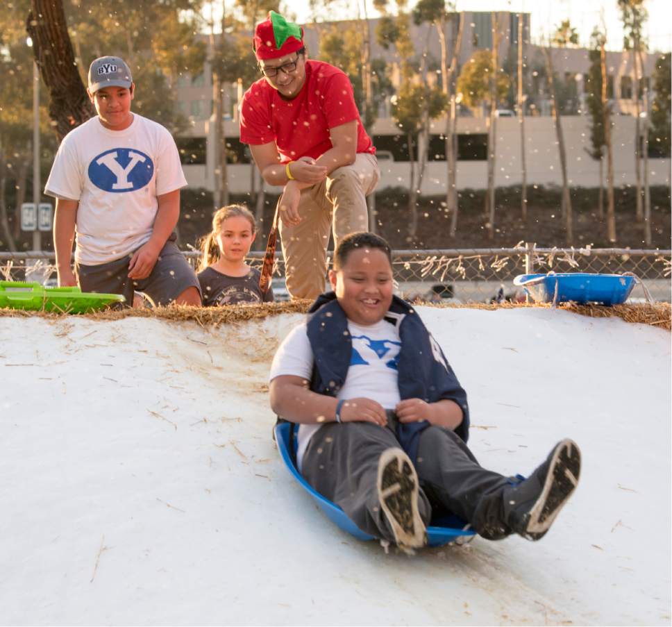 Rick Egan  |  The Salt Lake Tribune

BYU fan, Molonai Iongi takes a ride on a pile of snow in the parking lot of Qualcomm Stadium before the Poinsettia Bowl, Brigham Young Cougars vs. Wyoming Cowboys at Qualcomm Stadium in San Diego, December 21, 2016.