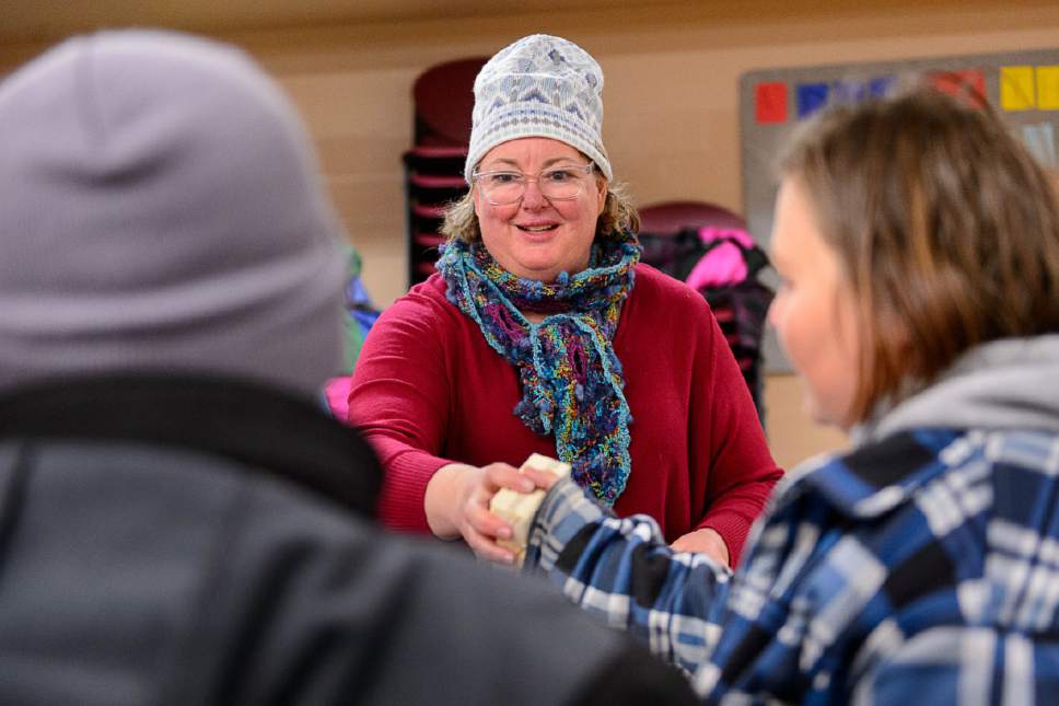 Trent Nelson  |  The Salt Lake Tribune
Volunteer Rhonda Nugent hands out food at the Rowland Hall & Crossroads Urban Center Holiday Meal Giveaway for Utah Families in Need in Salt Lake City, Friday December 23, 2016.