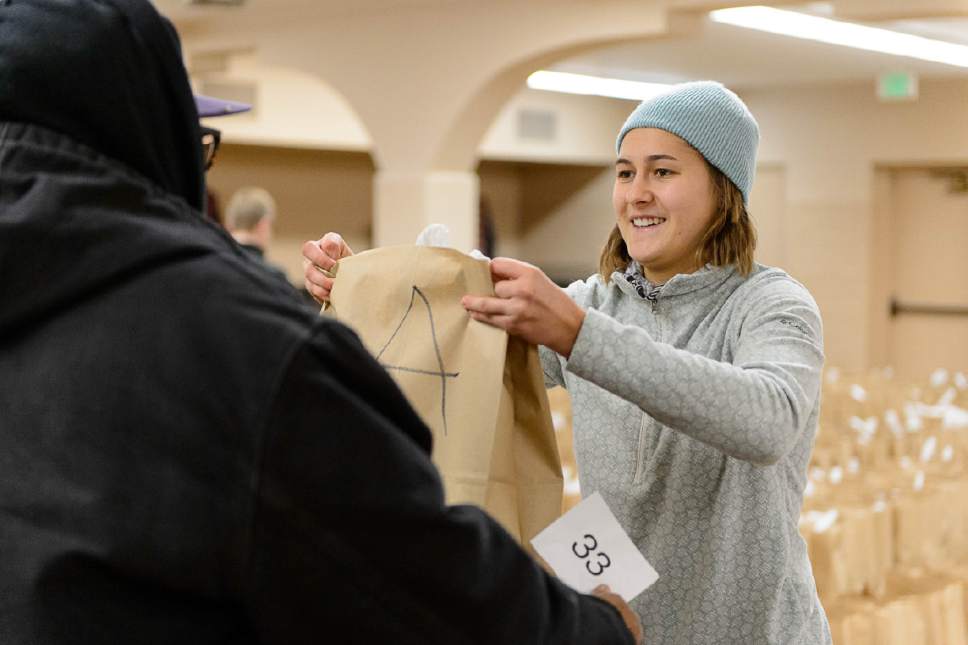 Trent Nelson  |  The Salt Lake Tribune
Volunteer Sophia Cutrubus hands out food at the Rowland Hall & Crossroads Urban Center Holiday Meal Giveaway for Utah Families in Need in Salt Lake City, Friday December 23, 2016.