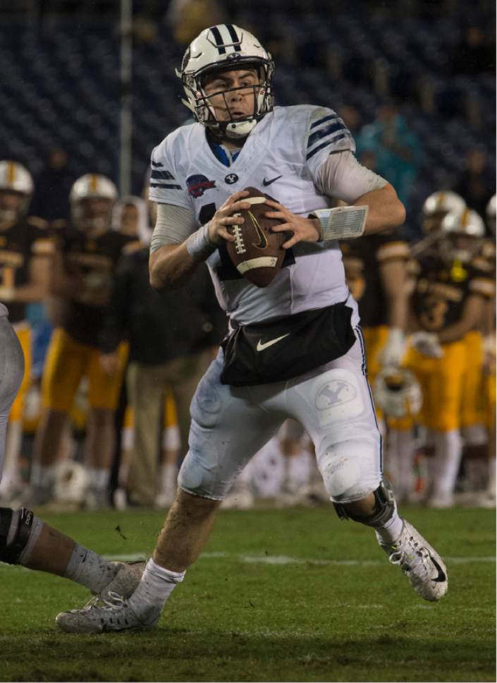 Rick Egan  |  The Salt Lake Tribune

Brigham Young quarterback Tanner Mangum (12) scrambles before throwing a touchdown pass for the Cougars, in football action, Brigham Young Cougars vs. Wyoming Cowboys in the Poinsettia Bowl, at Qualcomm Stadium in San Diego, December 21, 2016.