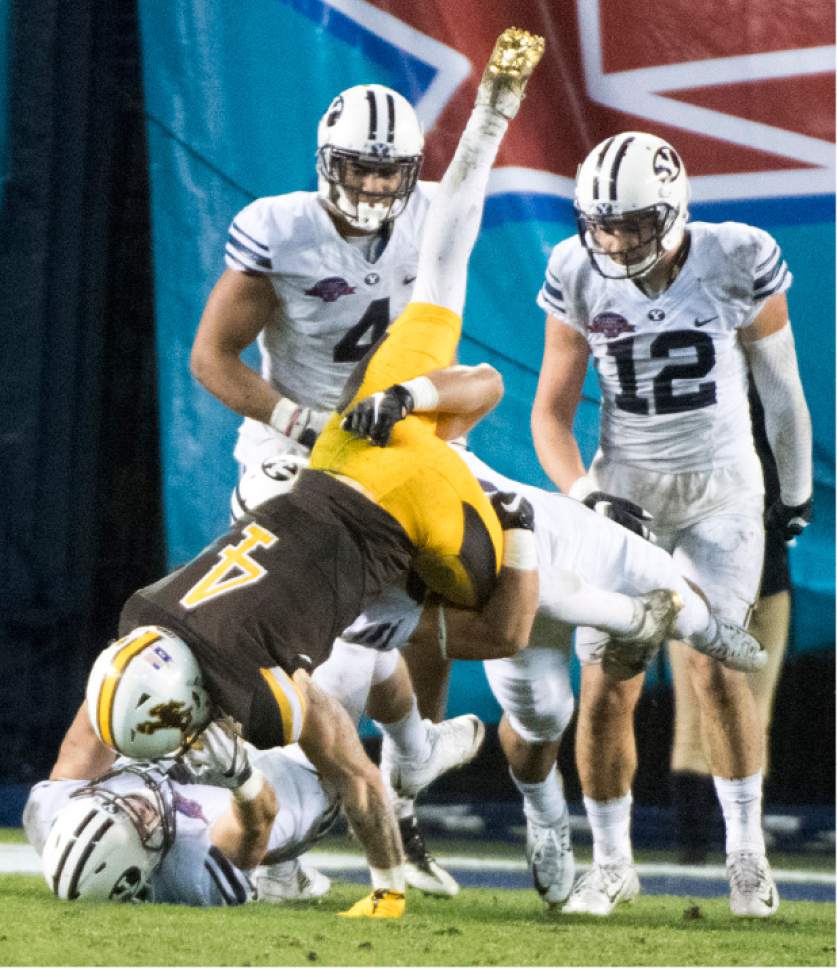 Rick Egan  |  The Salt Lake Tribune

Brigham Young Cougars linebacker Adam Pulsipher (41) pulls down Wyoming Cowboys wide receiver Tanner Gentry (4) with a little help from a team mate, as BYU defeated Wyoming 24-21in the Poinsettia Bowl, at Qualcomm Stadium in San Diego, December 21, 2016.