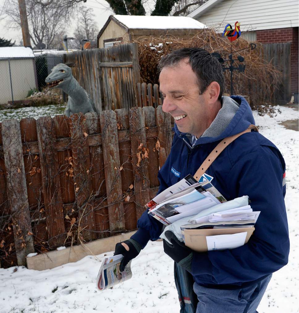Al Hartmann  |  The Salt Lake Tribune
Postal carrier Ben Frost delivers mail and packages on his regular route in Murray Thursday Dec. 22, the U.S. Post Office's busiest delivery day of the year. A record-breaking 300,000 packages are expected to be delivered in Utah. Frost, a seasoned carrier expects long days and more mail and packages this time of year and just deals with it in stride, even dinosaurs in backyards.
