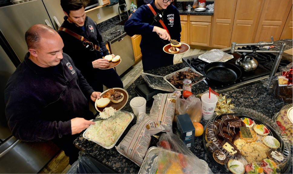 Scott Sommerdorf   |  The Salt Lake Tribune  
Firefighter paramedics Brad Jewett, left, Michael Buchanan, and Deena Walker prepare their plates of R&R BBQ at the Unified Fire Station in Draper on Saturda. In the background is Fire Capatin Paul "Hareball" Hare.