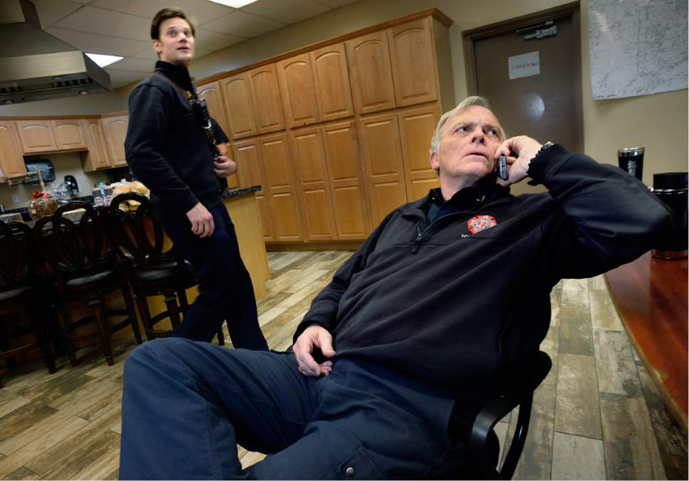 Scott Sommerdorf   |  The Salt Lake Tribune  
Fire Captain Paul "Hareball" Hare, right, looks at a call coming in as Michael Buchanan of Ambulance 214 walks past at the Unified Fire Station in Draper on Saturday.