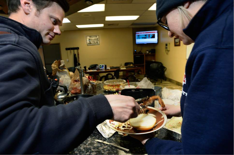 Scott Sommerdorf   |  The Salt Lake Tribune  
Michael Buchanan, left helps Denna Walker with a helping of fried chicken as the two paramedics with Ambulance 214 help themselves to part of the lunch donated by R&R BBQ at the Unified Fire Station in Draper, Saturday, December 24, 2016.
