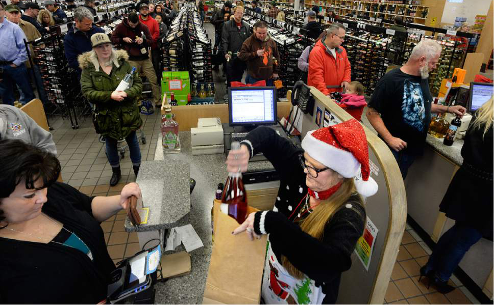 Scott Sommerdorf   |  The Salt Lake Tribune  
Cashier Cayra Peterson bags up an order as some lines are 10 people deep at the State Liquor and Wine store at 125 West and 900 South in Sandy, Saturday, Dec. 24, 2016.